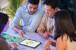 © weedezign - diversity team brainstorming focused on ESG (environment,social,governance)  with tablet or sdgs goals in a sustainable green office at night