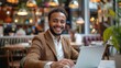 © Pravinrus - Young businessman smile sitting and working with computer laptop in coffee shop. enjoying the flexibility of remote work