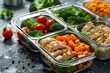 © Benjawan - A clean photo of a meal prep setup featuring containers with grilled chicken, quinoa, and mixed vegetables. Emphasize the organization, portion control, and balanced nutrition of the meal prep