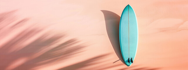 Wall Mural - A pastel turquoise surfboard with a simple design on a light pastel peach background. Summer concept banner with copy space