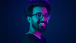 © Yuliia - Portrait Indian man standing in profile side view turn to camera smiling toothy happy guy developer coding smile computer internet technology hacker Arabian male neon ultraviolet high-tech cyberspace
