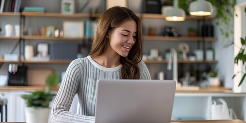 Wall Mural - A young woman sits confidently at her office desk, working on her laptop with a modern, professional demeanor