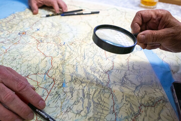 Several unseen people study a map of Morocco to see the most appropriate travel route through the beautiful North African country. only the hands are seen