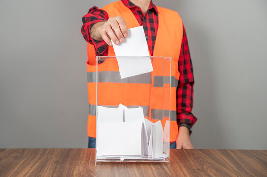 A voter casting a ballot into a ballot box on election day. Referendum, democracy,  plebiscite, trade union or labor union concept