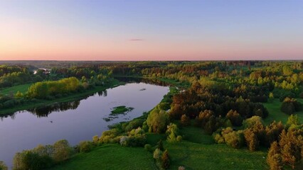 Wall Mural - a beautiful evening with a rosy sunset over the forest and river in summer. drone view