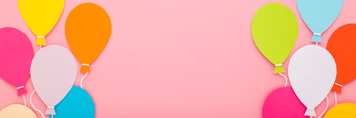Wall Mural - Colorful balloon shapes from application paper with white strings on pink table background. Pastel color. Closeup. Wide banner. Empty place for inspirational text, quote or sayings. Top down view.