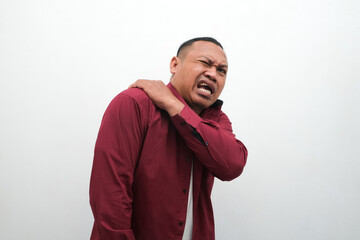 Wall Mural - Man feels pain his shoulder isolated studio shot. isolated white background