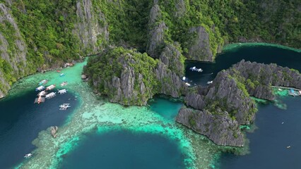 Wall Mural - Aerial view of tropical island. Boats in blue lagoons, rocks cliffs mountains and coral reef, Philippines, 4k