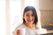 © Austockphoto - Close-up photo of a young girl smiling while holding a white cup
