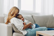 © SHOTPRIME STUDIO - Mother and child bonding on a cozy couch with a coffee table in the background against a white wall