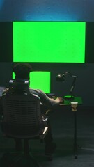 Fototapete - African American man works on computer in modern studio with equipment. Multiple green screen big monitors on the wall. Professional software displayed on tablet. Color grading or film editing room.