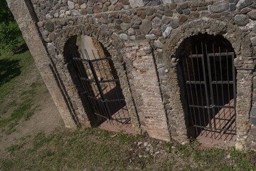 antic stone grotto with two closed iron grated doors