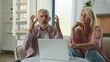 © Yuliia - Elderly senior family Caucasian couple mature woman man grandparents having emotional discussion husband wife arguing dispute female male talking online remote conference use laptop pc home quarrel
