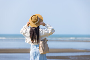 Wall Mural - Tourist woman with hand raise up and look at the sea