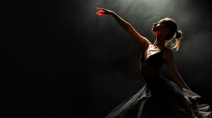 Ballet dancer poised in arabesque against a shadowy black background exuding grace and discipline 