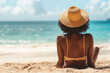 © Hatai - back full body woman and beach hat sitting on the beach and blue sky