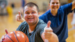 © Frank Gärtner - Two happy young individuals, one with down syndrome, giving a thumbs up and smiling on a basketball court