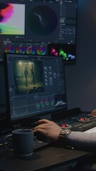 Fototapete - African American film maker makes color grading on computer in modern studio. Big screen with RGB colour correction graphic bar on wall. Action film footage displayed on monitor. Colorist equipment.