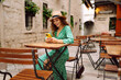Happy young woman holding smart phone and reading text message on mobile phone at coffee shop. People, fashion, lifestyle, travel and vacations concept.