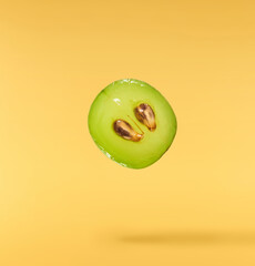 Wall Mural - Fresh green grape falling in the air isolated on yellow background. High resolution image.