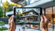 © Balica - Person holding tablet in hands, taking picture suburban house, virtual showing of modern country house, demonstration real estate on tablet screen.