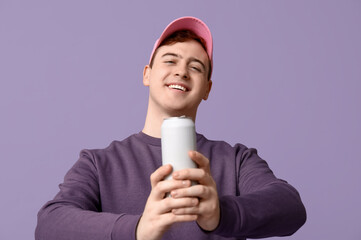 Poster - Young man in cap with can of soda on lilac background