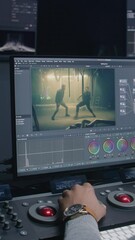 Fototapete - African American film editor does color grading on control surface in modern studio. Big monitors with movie footage and RGB colour correction graphic bar on the wall. Video post production process.