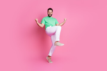 Sticker - Full size photo of overjoyed guy dressed green t-shirt white pants raising fists scream yeah win bet isolated on pink color background