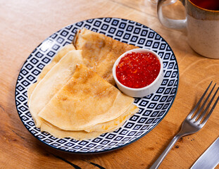 Wall Mural - Pancakes with red caviar dished up in flat service plate. Traditional Russian cuisine