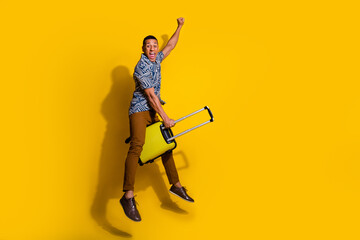 Sticker - Full length photo of cheerful positive guy dressed print shirt jumping riding luggage empty space isolated yellow color background