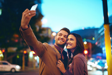 Wall Mural - Selfie, couple and city with love at night outside on honeymoon for marriage with happiness. Romantic, relationship and profile picture for social media with smile or hugging in New York with embrace