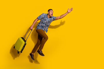 Sticker - Full length photo of funky cool guy dressed print shirt holding baggage jumping running empty space isolated yellow color background