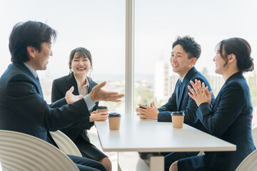 Poster - オフィスのカフェスペースで談笑するビジネスマン男女
