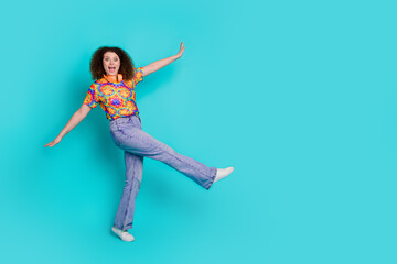 Wall Mural - Photo of positive lovely woman wear trendy print clothes dance walk empty space isolated on cyan color background
