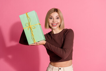 Wall Mural - Photo of positive nice pretty girl wear trendy brown clothes showing gift isolated on pink color background