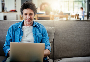 Poster - Laptop, businessman and smile on couch for relax, internet and reading or research in living room. Web designer, work from home and online for meeting, streaming and email for startup company on sofa