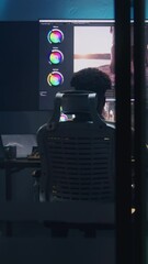 Fototapete - African American colorist does color grading in professional software on computer. Process of colour correction for video post production in modern studio. Multiple monitors with travel movie footage.