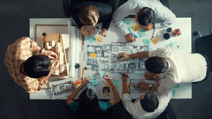 Wall Mural - Top aerial view of project manager or civil engineer writing at blueprint and planning building design. Aerial view of architect working together at meeting table with document placed. Alimentation.