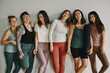 © Flamingo Images - Laughing group of young women in sportswear leaning against the wall of yoga studio after a class together