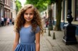 © MediaRaw - A young girl with long hair is standing on a sidewalk in front of a building