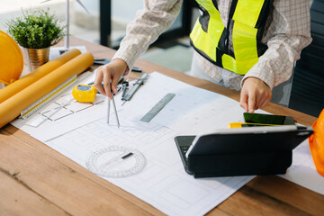 Wall Mural - businessman hand working and laptop with on on architectural project at construction site