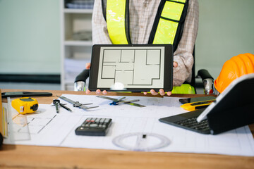 Wall Mural - businessman hand working and laptop with on on architectural project at construction site