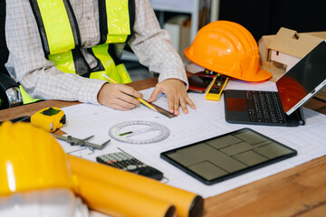 Wall Mural - businessman hand working and laptop with on on architectural project at construction site