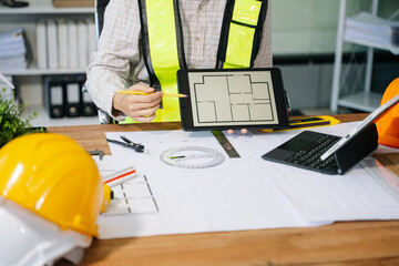 Wall Mural - businessman hand working and laptop with on on architectural project at construction site