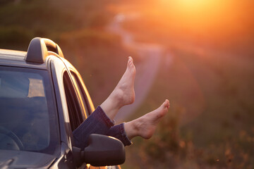 Summer travel concept with legs of a woman and car.