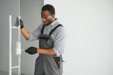 Wall Mural - Worker installing glass door at office