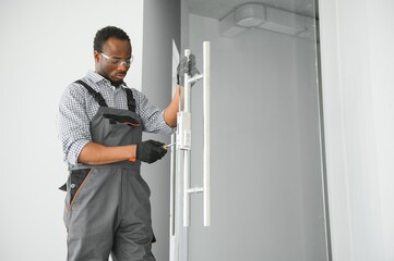 Wall Mural - Worker installing glass door at office