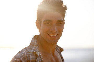 Happy, beach and portrait of man in summer for vacation, holiday and weekend outdoors. Nature, travel and face of person with smile for relaxing, adventure and sunshine by ocean on tropical island