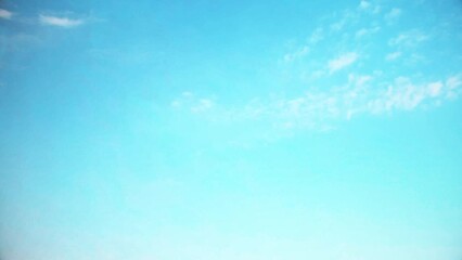 Wall Mural - Bright blue sky with small, fast moving clouds. Background with an atmospheric theme in soft, pastel colors.