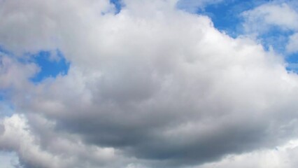 Wall Mural - Huge, low clouds slowly move across the sky. Cumulus white clouds with dark bottoms.
